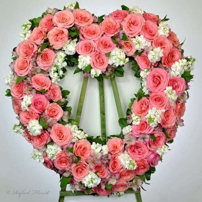 Heart shaped memorial wreath with pink roses and white stocks