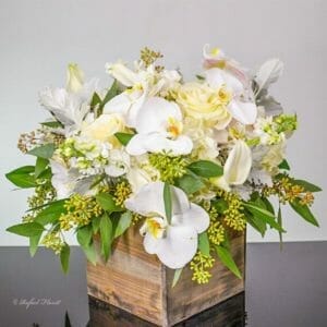 Rustic floral design of white phalaenopsis orchids, roses