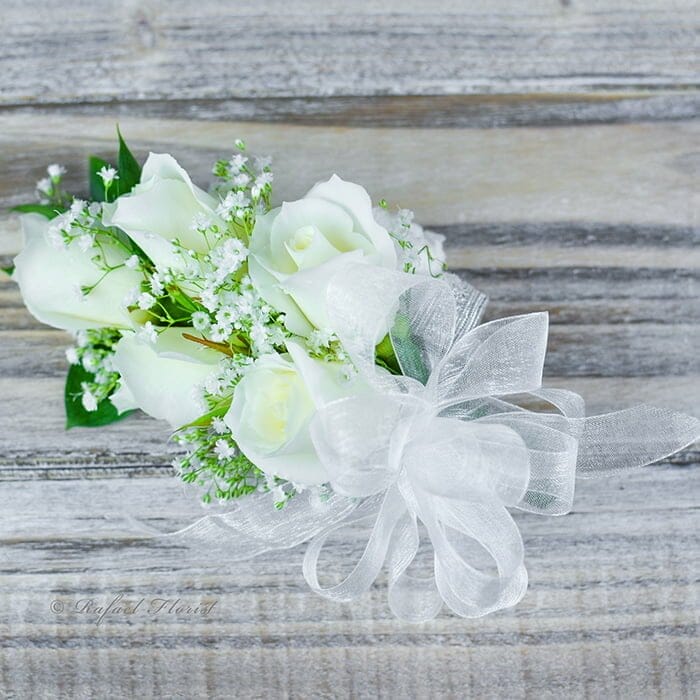 This classic prom wrist corsage of white baby roses and white ribbon