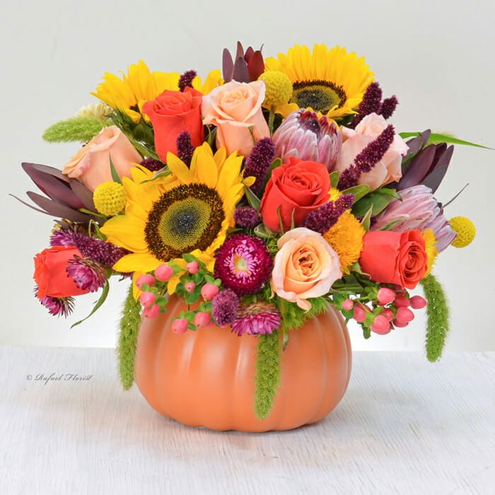 Colorful autumn flowers are designed in an orange ceramic pumpkin